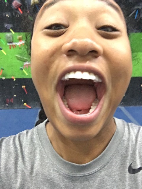 A close-up of a CAN lab member's face, very excited to be rock climbing